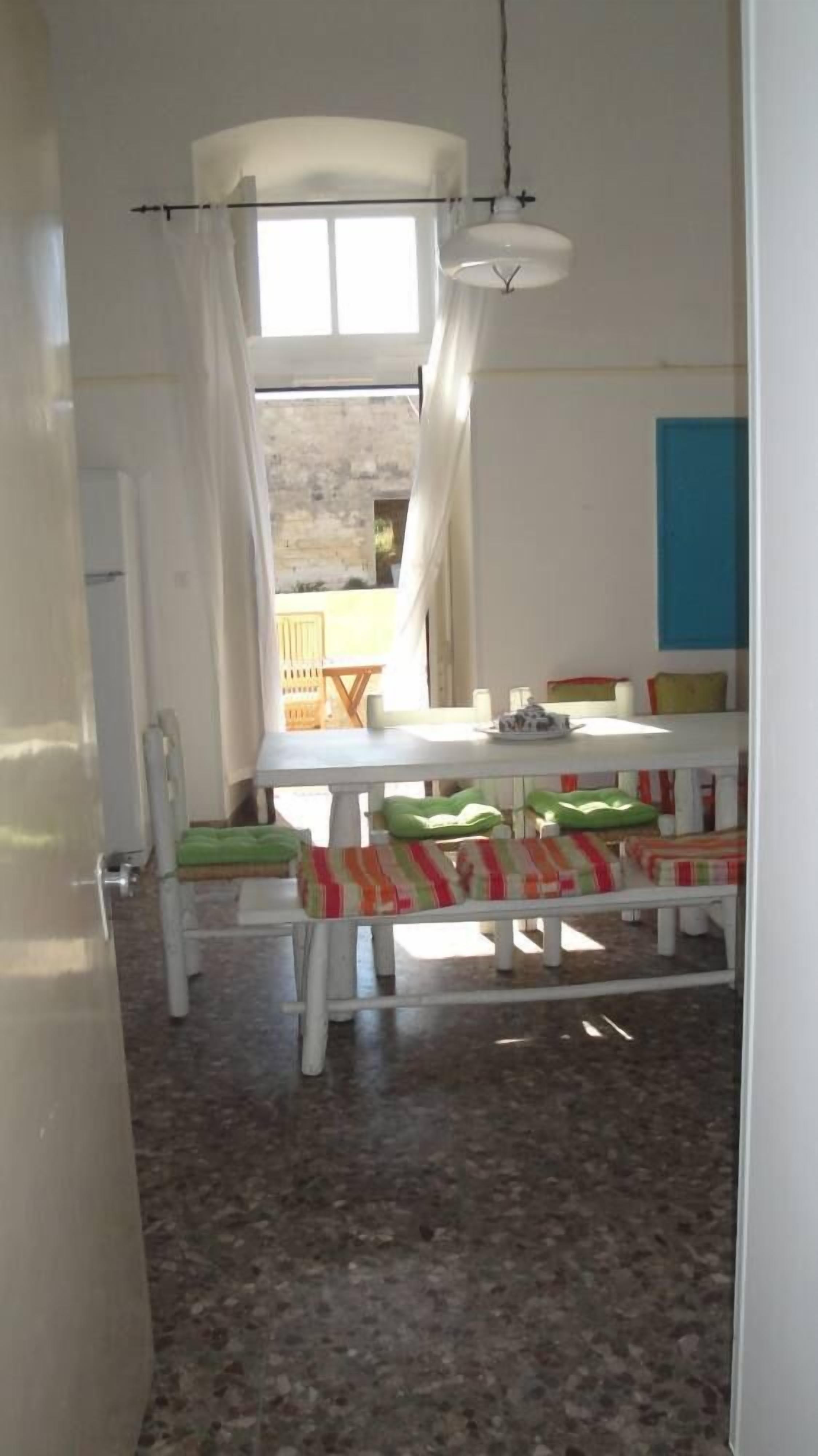 A room with a dining table, chairs, and a view of the outside.