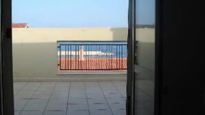 Uitzicht vanaf een balkon met betegelde vloer en metalen hekwerk.