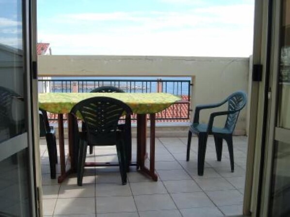 A balcony with a table and chairs, a view of the sky, and a railing. - Sardinia - Cala Gonone (Nuoro) – Sea & Mountain – 80m Away From The Sea. (Cala Gonone)