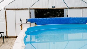 Una piscina cubierta con un toldo blanco y un borde azul.
