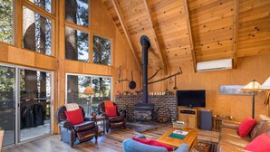 A spacious living area with a fireplace, leather furniture, and large windows. - Yosemite Vista (Yosemite National Park)
