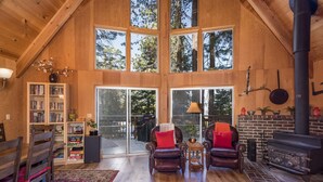 A spacious loft with high ceilings, large windows, a fireplace, and a bookshelf. - Yosemite Vista (Yosemite National Park)