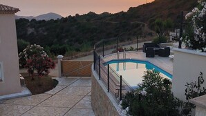 Et boligområde med swimmingpool, legeplads og udsigt til solnedgang.