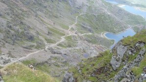 Un paysage montagneux avec une route sinueuse et un lac.