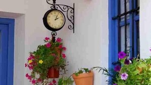 A room with a clock, blue window, and hanging flower pots. - Andalucia Center. Beautiful house (ENCINAS REALES)