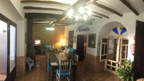 A spacious living area with a dining table, chairs, and a sofa. There is a staircase with colorful steps and a door leading to another room. - Andalucia Center. Beautiful house (ENCINAS REALES)