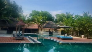 A swimming pool with lounge chairs and a gazebo.