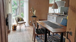 Una cocina acogedora con una mesa de comedor, una silla y una lámpara colgante.