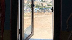 Ein Durchgang zu einem Balkon mit Blick auf eine Stadtlandschaft und das Meer.