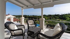 A covered outdoor seating area with wicker furniture and a view of the landscape. - Villa Sun - charming villa, heated pool, full privacy, wedding, near Dubrovnik (Cavtat)