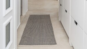 A hallway with a white door, a black and white striped rug, a white cabinet, and a ceiling light. - Villa Sun - charming villa, heated pool, full privacy, wedding, near Dubrovnik (Cavtat)