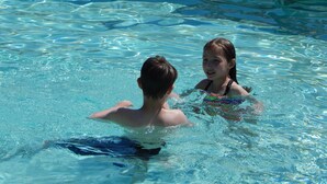 Ein Schwimmbecken mit klarem Wasser und gefliesten Rändern.