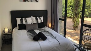 A neatly made bed with white and black bedding, a headboard, and a painting of a bicycle on the wall. - 4* architect's villa, contemporary, air-conditioned with heated swimming pool (Zonza)