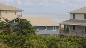 Una zona residenziale sul lungomare, con case, una recinzione in legno e vista mare.