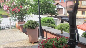 A courtyard with potted plants, a street lamp, and a building with solar panels. - well-equipped apartment in a quiet forest location (Ramberg)