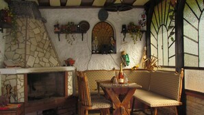 A cozy room with a stone fireplace, wooden furniture, and a decorative mirror. - well-equipped apartment in a quiet forest location (Ramberg)