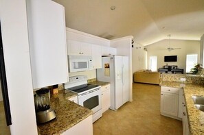 Enjoy cooking in this well-equipped kitchen with a microwave, oven, refrigerator, and blender.