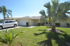 Stylish single-story home with a garage and lush surroundings.