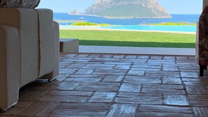 A room with a view of a beach and a mountain.