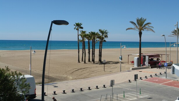 A beachside parking area with a clear view of the ocean, palm trees, and a small kiosk. - Apartment/ flat - Coma-ruga El Vendrell (Coma-Ruga)