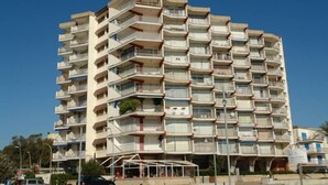A multi-story residential building with balconies, a covered outdoor area, and a clear blue sky. - Apartment/ flat - Coma-ruga El Vendrell (Coma-Ruga)