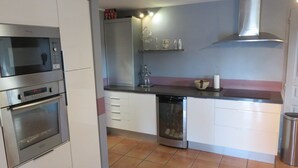 A compact kitchen with a built-in oven, microwave, and dishwasher.