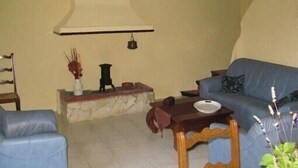 Ein Wohnzimmer mit einem blauen Sofa, einem Holztisch und einem Kamin aus Marmor.