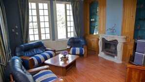 A living room with leather sofas, a wooden coffee table, and a fireplace. - Beautiful 16th century house (Saumur)