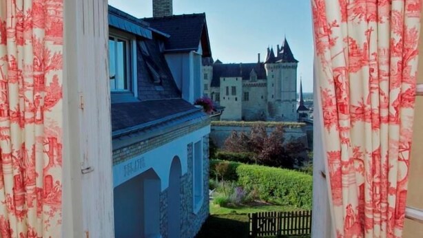 A view from a window overlooking a castle and a building with a stone facade. - Beautiful 16th century house (Saumur)