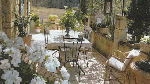 An outdoor patio with a table and chairs, surrounded by potted plants and flowers. - 200 meters from the heart of the village, App 55 M² WiFi In a closed courtyard, quiet (Châteauneuf-De-Gadagne)