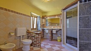 Un baño con inodoro, bidé y lavamanos.