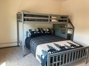 A bunk bed with a blue and white patterned bedspread and matching pillows.