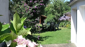 A garden with a table and chairs, a wooden structure, and various plants. - House 2-7 people, 150m from the beach Tregastel White Strike, Near Perros-Guirec (Trégastel)