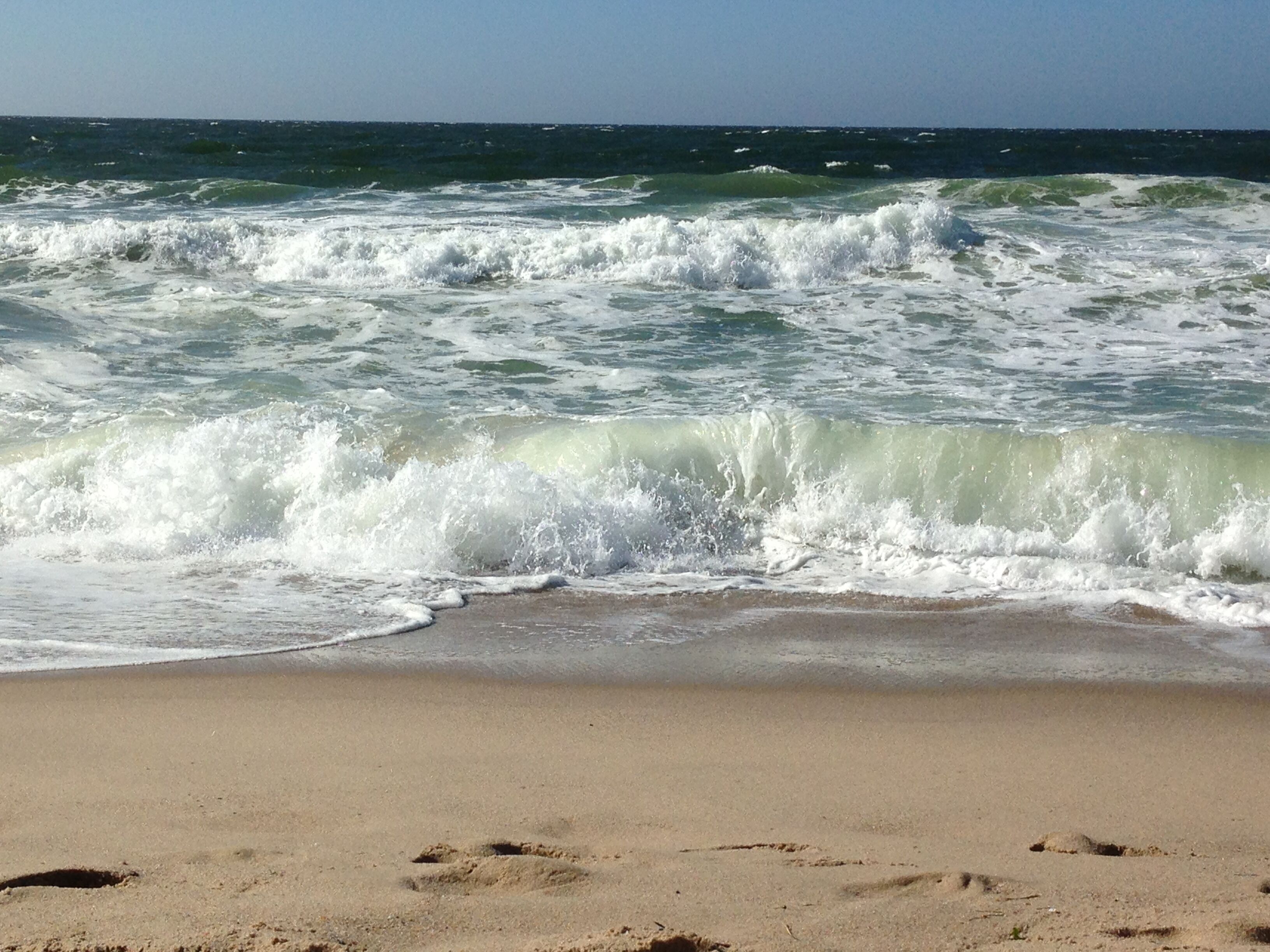 A beach with waves approaching the shore.