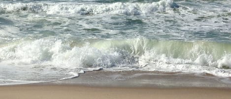 A beach with waves approaching the shore.