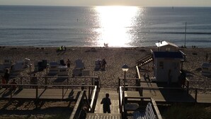 A beach with a wooden boardwalk leading to a lifeguard station. - quiet duplex apartment, modern and bright (Sylt-Ost)