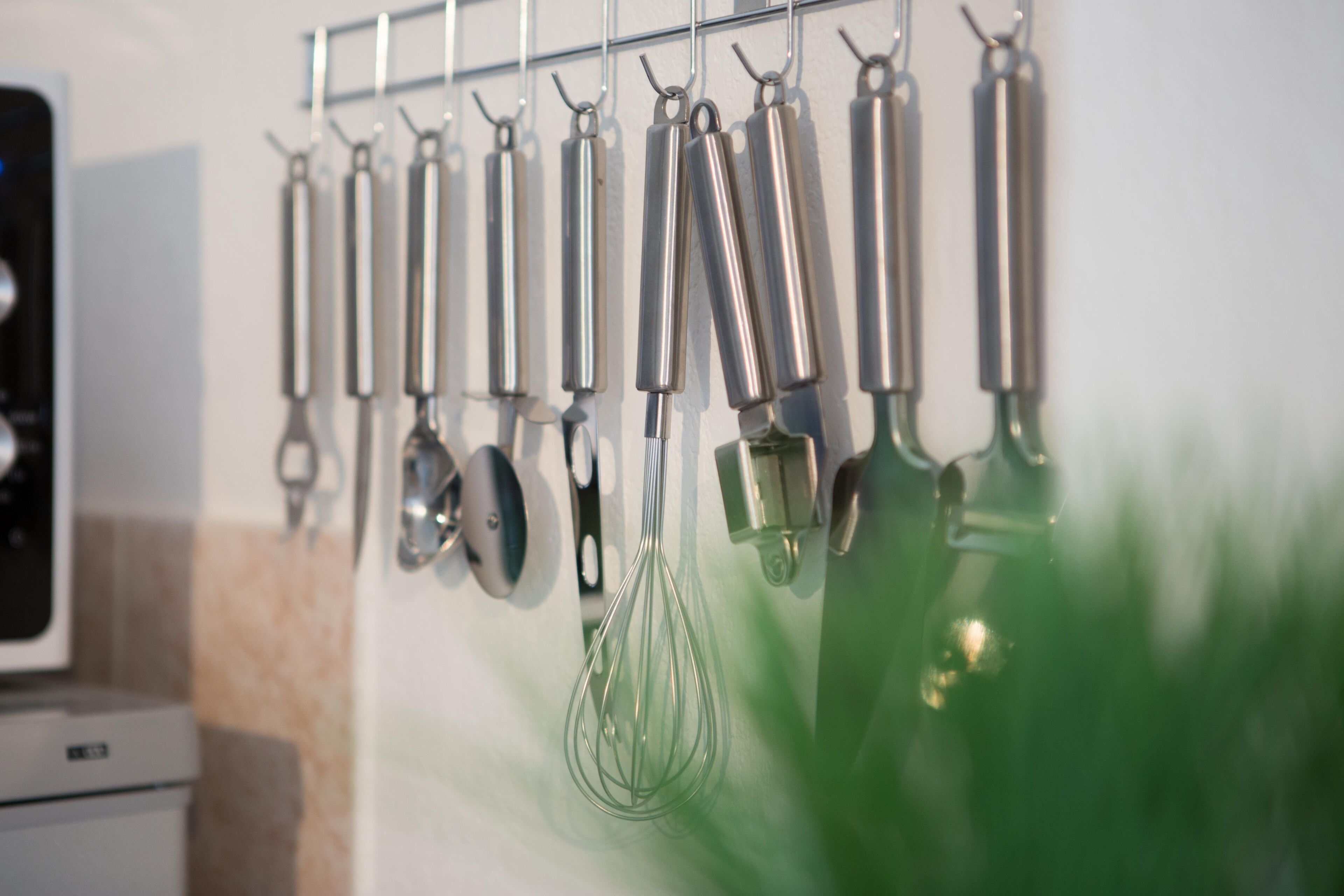 Een keuken met verschillende keukengerei dat aan een rek hangt.