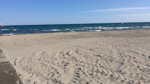 A sandy beach with a clear sky and calm sea.