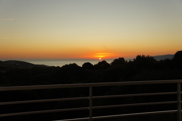 A sunset over a hilly landscape with a metal railing in the foreground. - Propriano, sea view, pool, 4 bedrooms, 4 bathrooms (Viggianello)