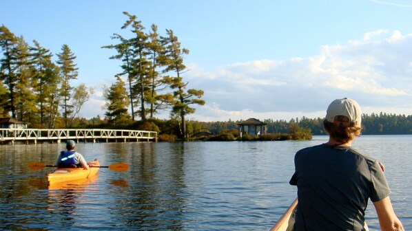 A calm lake with a wooden dock and a small pavilion. - Longfellow a Traditional Cabin (Paul Smiths)