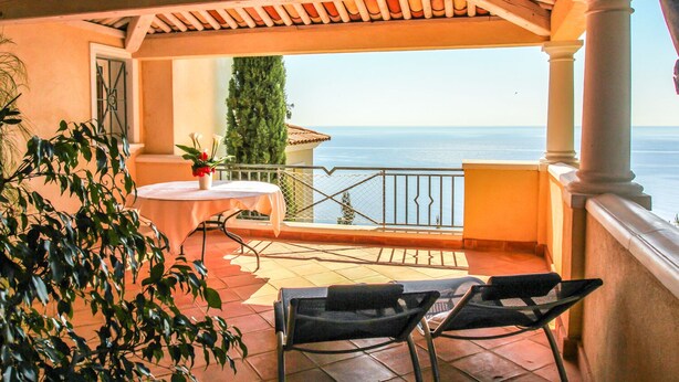 A covered outdoor area with a table and chairs, a potted plant, and a view of the sea. - CHARMING STUDIO 28m2 terrace 22m2 PANORAMA MER / MASSIF DE L'ESTEREL (Théoule-Sur-Mer)