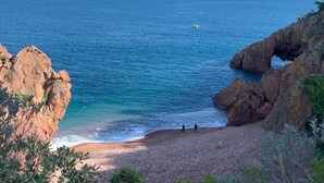 A coastal landscape with rocky cliffs, a clear blue sea, and a small boat in the distance. - CHARMING STUDIO 28m2 terrace 22m2 PANORAMA MER / MASSIF DE L'ESTEREL (Théoule-Sur-Mer)