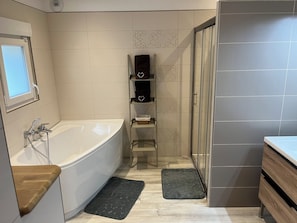 A modern bathroom with a bathtub, shower, and vanity. - L'OASIS DE BOISSET: 5* VILLA, 3 min from Anduze, private SWIMMING POOL / SPA, 10/14 per (Boisset-Et-Gaujac)