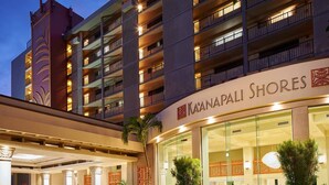 Ein Hotel mit mehreren Stockwerken, einem markanten Eingangsbereich mit Überdachung und einem Schild mit der Aufschrift "Ka'anapali Shores".