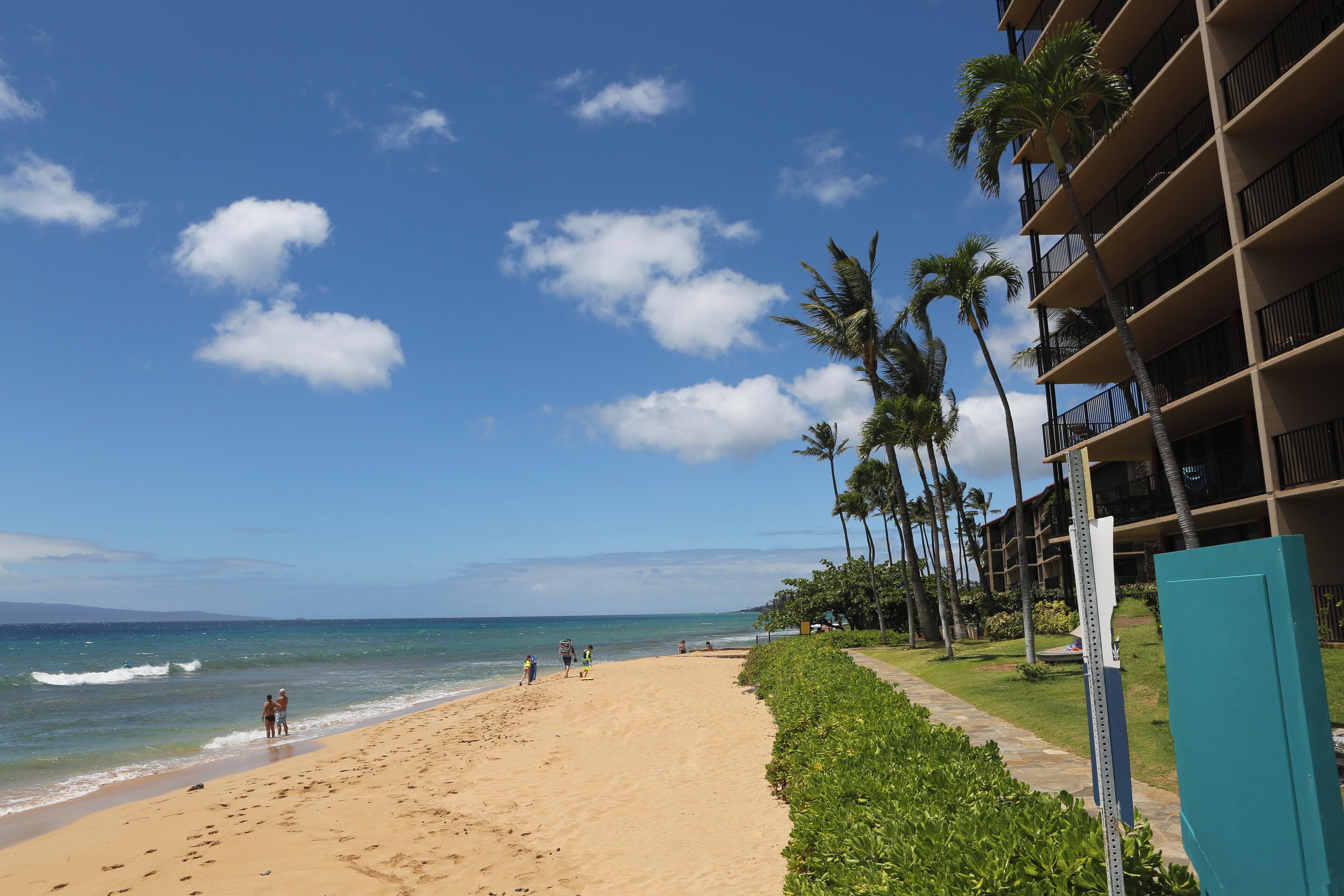 Una playa con un hotel al fondo.