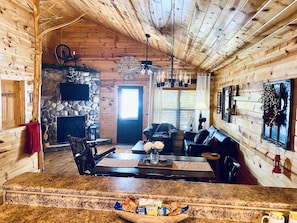 Ein gemütliches Blockhaus-Interieur mit Kamin aus Stein, Holzboden und Steinwand.