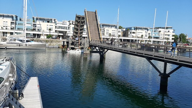 A bridge over a marina with boats docked, a clear sky, and modern buildings in the background. - Pleasant T2 excellent location near the old port secure parking, Wifi (La Rochelle)