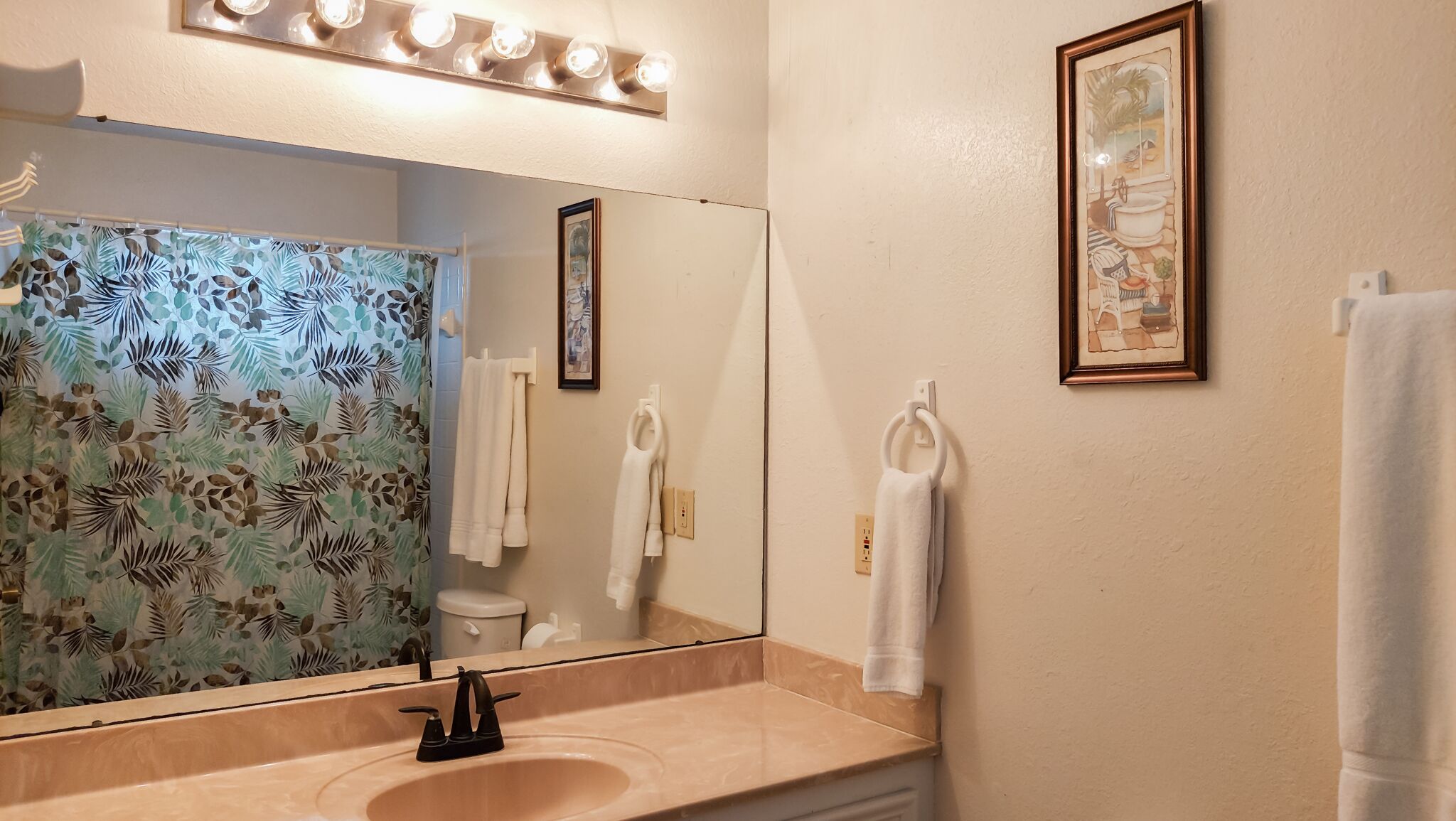 Une salle de bain équipée d’un lavabo, d’un miroir et d’un porte-serviettes.