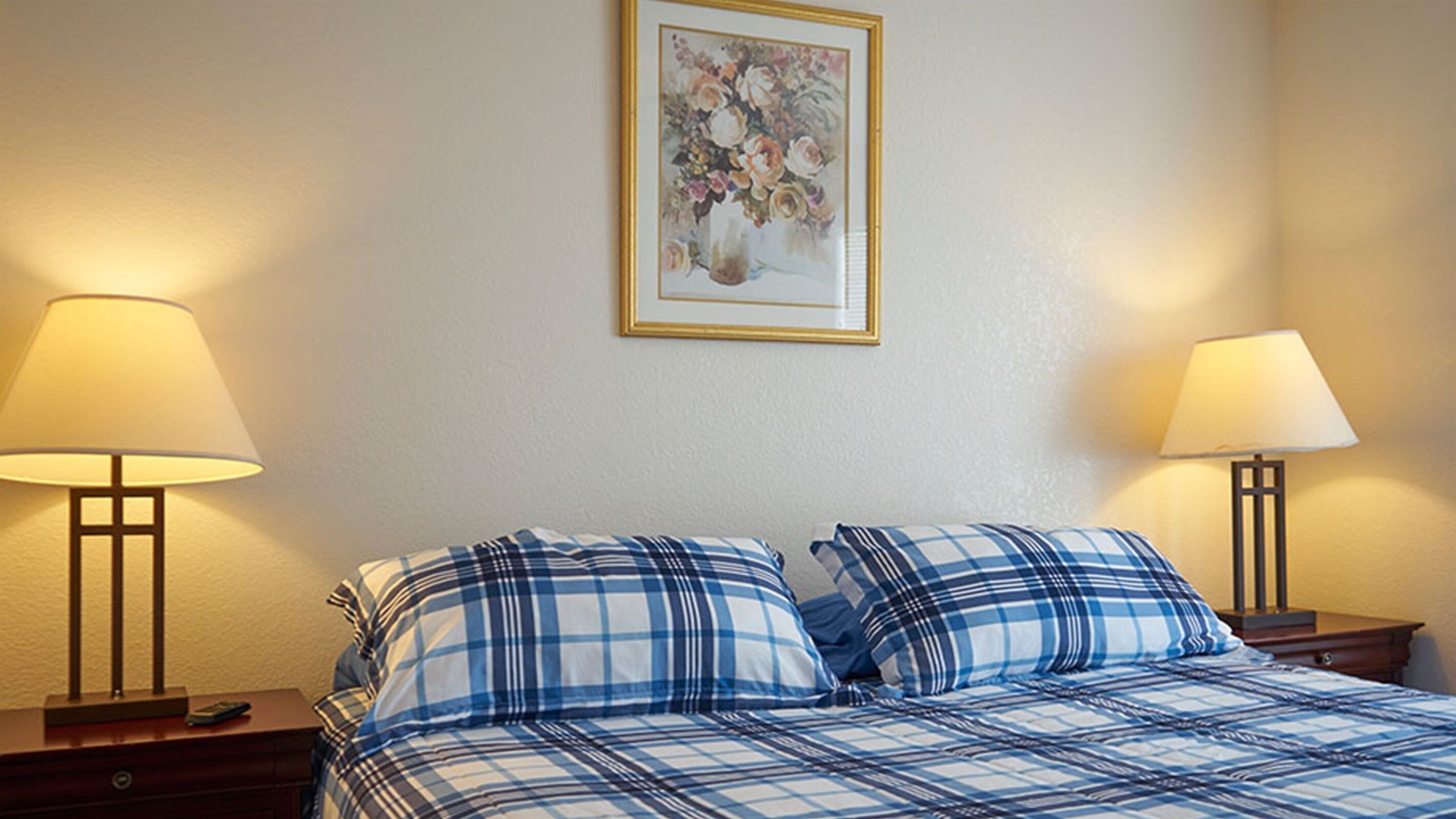Ein Hotelzimmer mit einem Bett, zwei Nachttischen und zwei Lampen.
