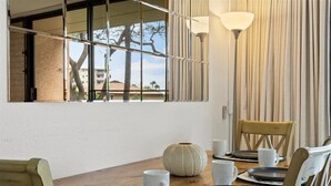 A dining area with a wooden table set for four, including plates, cups, and a vase. - Quiet, comfortable and across from gorgeous Charley Young beach  (Kihei)